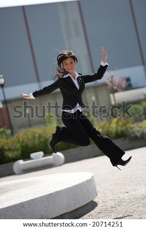 full figure with jump of a young adult businesswoman outdoors in a sunny day