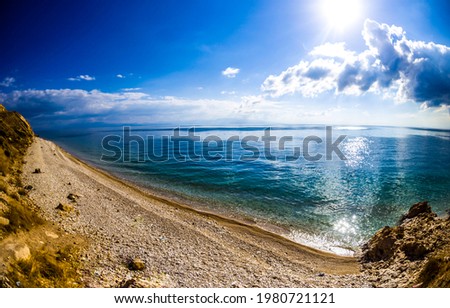 Lake shore at the foot of the mountain. Mountain lake beach landscape. Lake beach in mountains