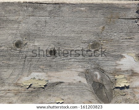Old grey wood texture with a coarse, scratched surface, small knots, and a few areas of chipping white paint.