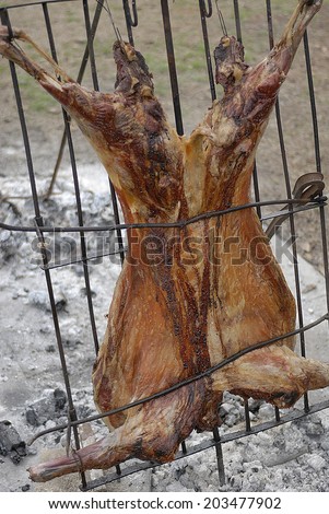 Asado, traditional barbecue dish in Argentina, roasted meat of beef, ram,  and others cooked on a vertical grills placed around fire