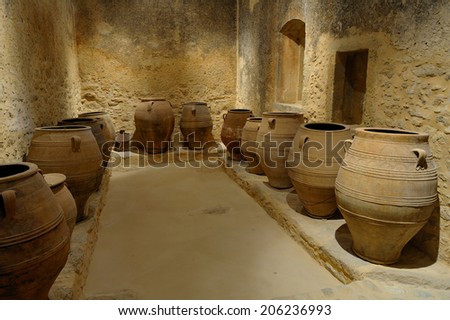 Crete, Greece, February. 3. 2009: Old olive oil factory with stone mill and ancient vase, island of Crete, Greece