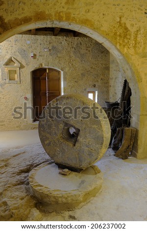 Crete, Greece, February. 3. 2009: Old olive oil factory with stone mill and ancient vase, island of Crete, Greece