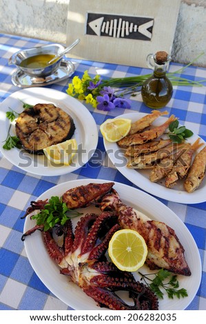 Grilled sardine, octopus, shrimp with olive oil and white wine, traditional Greek food at the restaurant near the bay, island of Crete, Greece