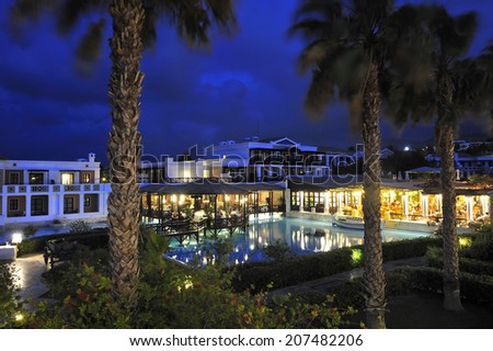 swimming pool with open-air restaurant in night illumination at the modern luxury hotel, Crete, Greece