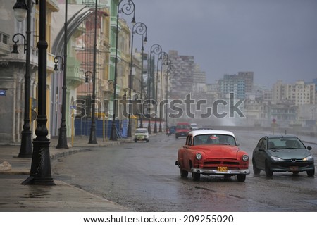 HAVANA, CUBA, - November. 5. 2010: classic cars running through Malecon, the broad roadway and seawall along the coast in Havana, Cuba