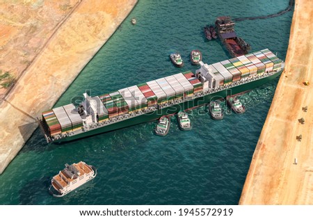Ever given has been freed in Suez Canal. Effort to refloat vast wedged container cargo ship by tug boats, dredger ship 3D illustration. Giant cargo ship dislodged and refloated in Egyptian Suez canal Foto stock © 