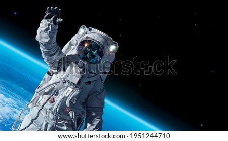 12 April 1969, International day of human space flight, Cosmonautics Day concept with ISS astronaut in spacesuit against background of the Earth planet. Spaceman in outer space 3D science illustration