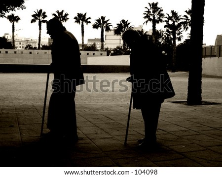 Old man and woman walking with sticks