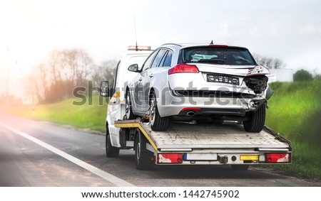 Loading broken car on a tow truck. Damage vehicle after crash accident on the highway road. Stock foto © 
