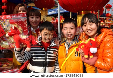 Pengzhou, China January 22, 2014:  Happy vendors selling Year of the Horse decorations and toys for the Chinese New Year holiday commencing 31 January 2014