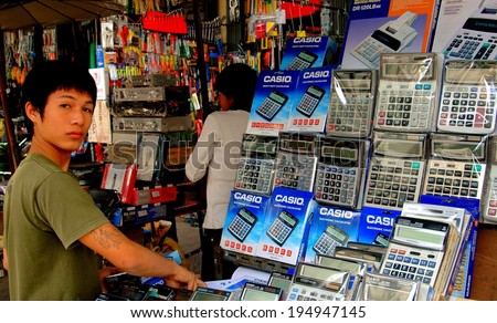Bangkok, Thailand - December 20, 2005:  Young vendor selling Casio adding machines on busy Yaowarat Street in the Chinatown district