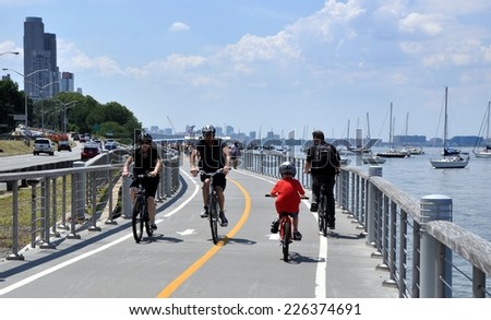 NYC - July 15, 2011:  Bicyclists enjoy a summer afternoon on the Hudson River bike path sandwiched between the Hudson River and the Miller Highway (Router 9) on the west side of Manhattan