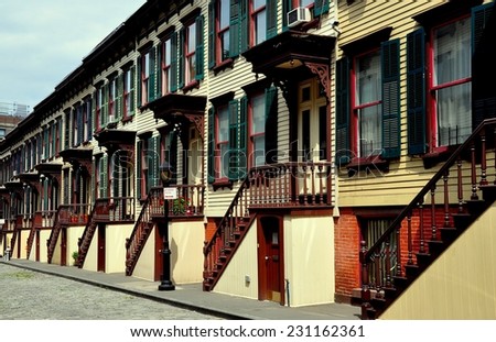 New York City - August 10, 2013:  Two story 1882 wooden row houses with stairway stoops and basement entry doors on Sylvan Terrace in the Jumel Historic District between West 162nd and 163rd Streets *