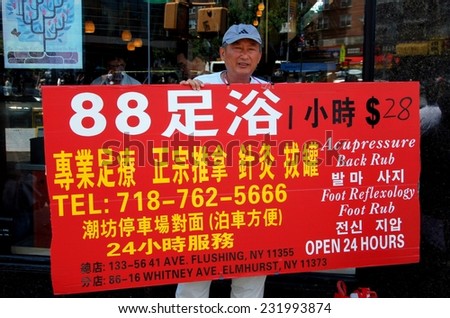 Flushing, New York - June 26, 2007:  Man holding a large advertising sign  for an acupressure, back rub, and foot reflexology spa services