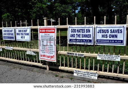 Queens, New York - May 11, 2012:  A religious zealot\'s signs about God and Jesus hang on a fence at King Park on Jamaica Avenue