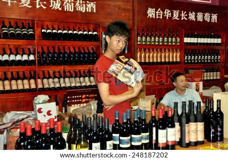 Chengdu, China - September 15, 2010:  Vendors at their booth selling local Chinese and European wines at the 10th Chinese Moon Cake Festival at the annual Sichuan and Tianfu Food Fair