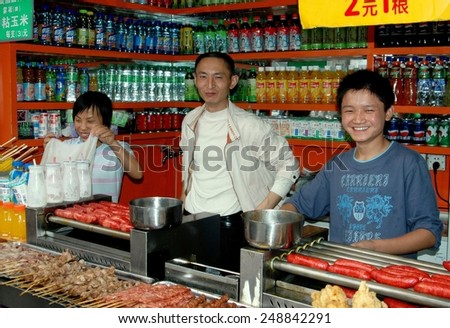 Chengdu, China - September 20, 2006:  Family in their food shop on Qing Nian Lu selling sodas and variety of grilled meats and sausages