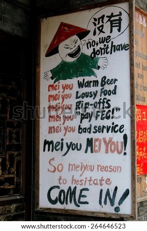 Yangshuo, China - April  30, 2008:  An amusing sign at the Mei You bar-restaurant on West Street invites patrons to come in