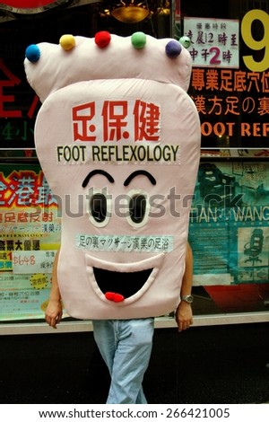 Hong Kong, China - August 17, 2006:  Man dressed in a foot costume advertising a foot reflexology shop on Nathan Road in Kowloon
