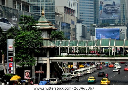 Bangkok, Thailand - January 22, 2013:  A covered bridge for pedestrians spans busy Thanon Ratchaprasong at the Central World and Isetan shopping malls