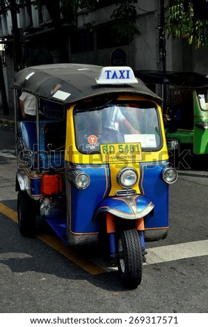 Bangkok, Thailand - December 16, 2009:  A typical Bangkok city tuk-tuk three-wheeled taxi cruising the streets looking for a fare