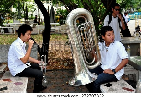 Bangkok, Thailand - January 25, 2013:  Students from a brass marching band with their instruments waiting to perform in Lumphini Park
