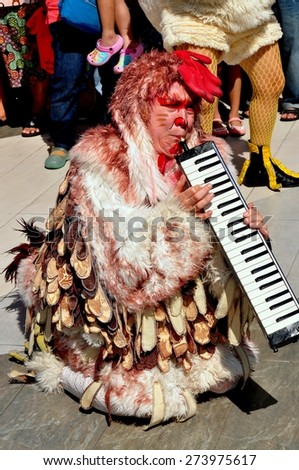 Bangkok, Thailand - January 11, 2013:  Musician in a chicken costume entertains crowds at the Children\'s Day festivities in the Siam Paragon shopping center outdoor plaza
