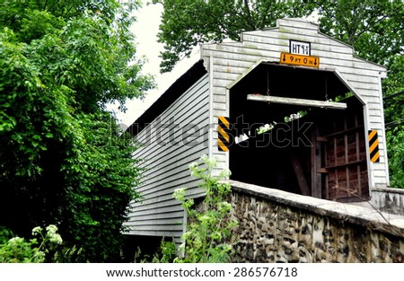 West Bradford, Pennsylvania - June 2, 2015:  1872 Gibson Covered Bridge built entirely of wood spans a small creek