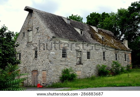Lititz, Pennsylvania - June 9, 2015:  Late 18th century old stone mill with shingled roof and small dormers on Market Street