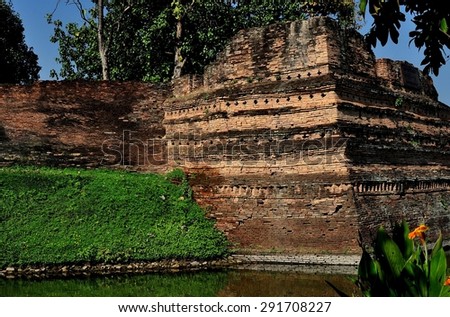 Chiang Mai, Thailand - December 29, 2012:   A portion of the ancient city defense walls can be seen at Si Phum Corner along with the surrounding medieval moat