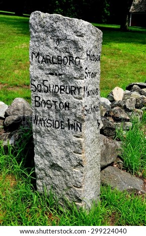 Sudbury, Massachusetts - July 12, 2015:  A colonial-era stone sign post shows directions to local towns on the old Boston Post Road