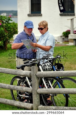Jamestown, Rhode Island - July 18, 2015:  Man and woman with their parked bicycles studying a road map at 1856 Beavertail State Park Lighthouse on Conanicut Island