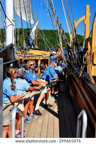 Mystic, Connecticut - July 11, 2015:  Crew members on deck pulling heavy rope aboard the 1841 Charles W. Morgan whaling ship at Mystic Seaport *