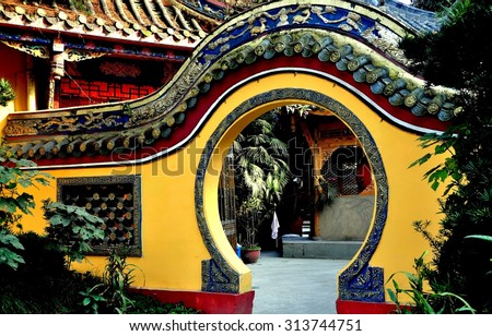 Pengzhou, China  November 13, 2013:  A moon gate flanked by gardens leads into an inner courtyard at the Ci Ji Buddhist Temple