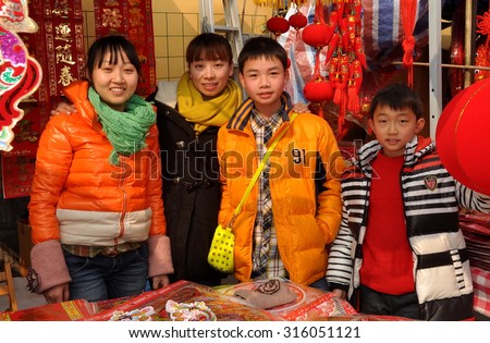 Pengzhou, China - January 21, 2014:  Happy vendors selling Year of the Horse decorations and toys for the Chinese New Year holiday, the Year of the Horse