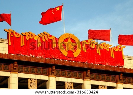 Beijing, China - May 1, 2005:  The Chinese flag flies above an immense gold star banner atop the roof of the National Museum of China in Tian\'anmen Square