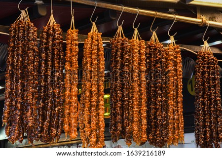 Cevizli sucuk made by dipping a string with walnuts into a grape molasses mixture, the sweet sucuk is then hung out to dry and cut into pieces and enjoyed as a gummi-like dessert. Sweet grape molasse Stok fotoğraf © 
