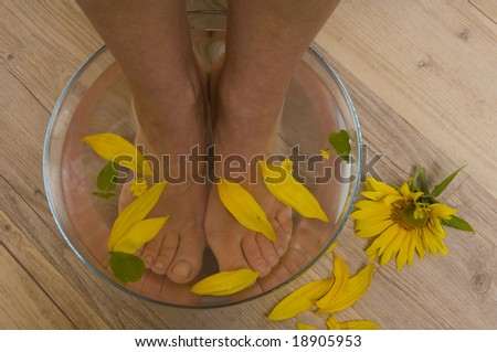 Foot soak , relaxing foot treatment with sunflowers in the water as a decoration