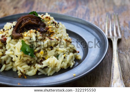 Wild mushrooms risotto served on a tin plate.