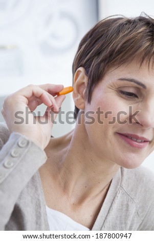 Noise control plugs with middle aged woman