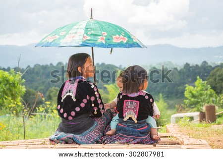Chiangmai, THAILAND - OCT 26, 2014: Three young girl Mhongs sit on the chair with little brother.