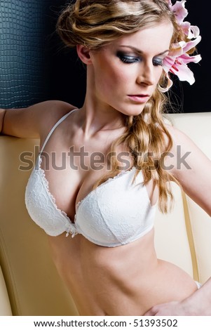 blonde in lingerie sitting  posing in sofa with madonna lily