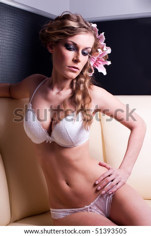 blonde in lingerie sitting  posing in sofa with madonna lily