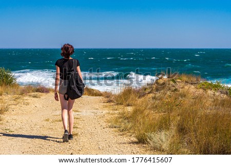 Similar – Foto Bild Person, die auf einer Landstraße zwischen Meer und Feld geht