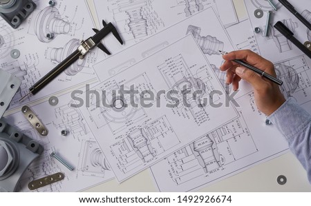 Engineer technician designing drawings mechanical parts engineering Enginemanufacturing factory Industry Industrial work project blueprints measuring bearings caliper tools ストックフォト © 