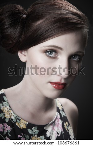 Vintage style portrait of model with red hair tied in a bun