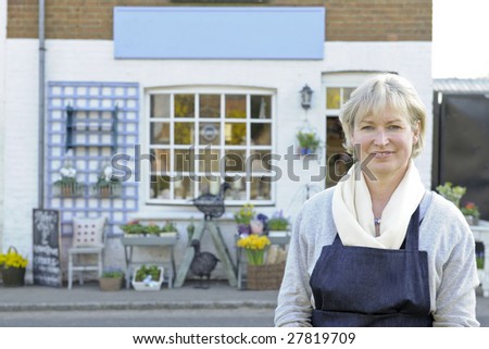 Florist standing outside her shop smiling at camera