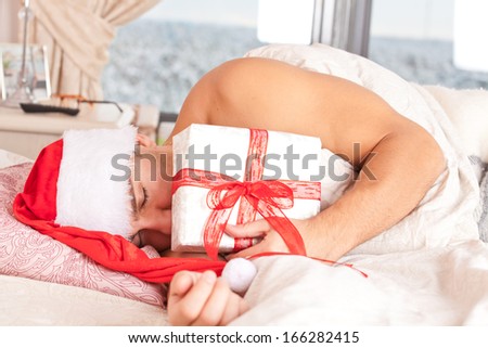 Santa Claus  sleeping in bed wth gift box