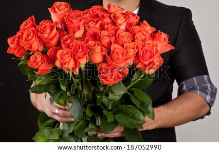 Beautiful big bouquet of red roses in man hands.