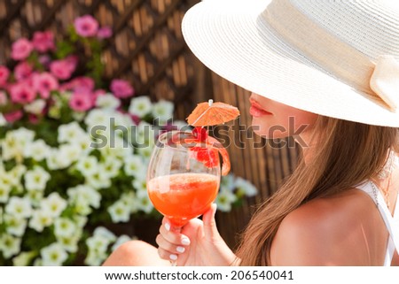 sensual woman in white hat relaxing with fresh juice. Summer vacation. (focus on face)